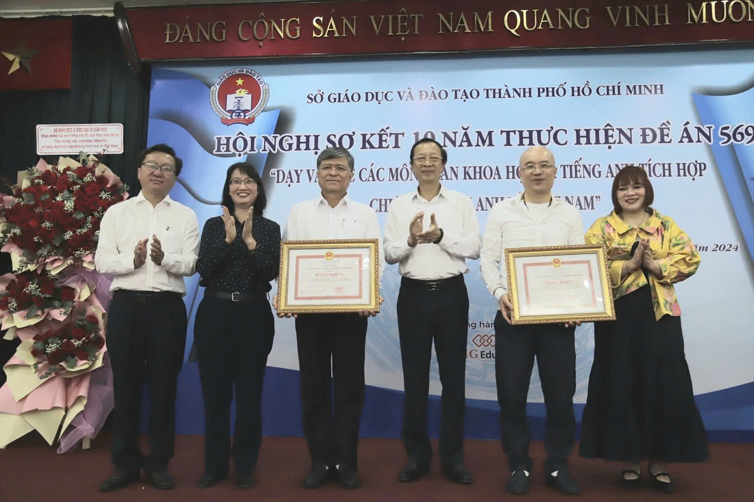 Ông Phạm Ngọc Thưởng, thứ trưởng Bộ Giáo dục và Đào tạo (thứ ba từ phải qua) và bà Trần Thị Diệu Thuý (thứ hai từ trái qua) trao bằng khen cho Sở Giáo dục và Đào tạo TP.HCM và EMG Education - Ảnh: NHƯ HÙNG